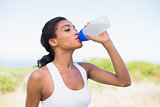 Fit woman drinking water from sports bottle