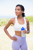 Fit woman holding sports bottle smiling