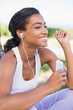 Fit woman sitting down listening to music