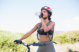Fit woman going for bike ride drinking water