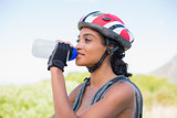 Fit woman going for bike ride drinking water