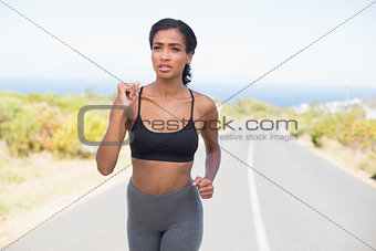 Fit woman running along the open road