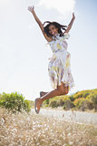 Happy pretty woman jumping up in floral dress