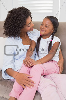Pretty mother sitting on the couch with her daughter
