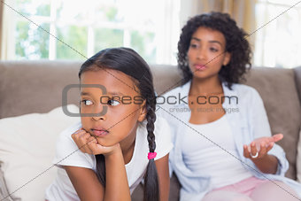 Pretty mother sitting on couch after an argument with daughter