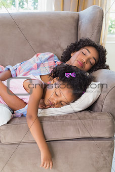 Pretty mother sleeping with her daughter on the couch