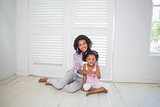 Mother and daughter sitting on the floor showing new house key