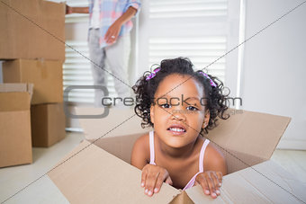 Cute daughter sitting in moving box