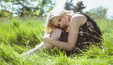 Pretty blonde in sundress sitting on grass