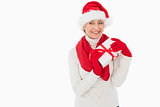 Festive woman smiling at camera holding a gift