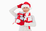 Festive woman scratching head and holding gifts