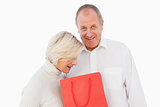 Older couple holding red gift bag