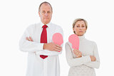 Older couple standing holding broken pink heart