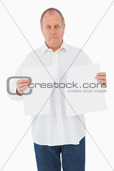 Serious man holding torn sheet of paper