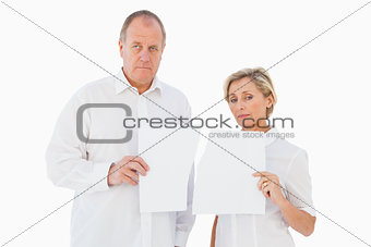 Upset couple holding torn piece of paper