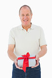 Mature man smiling at camera holding gift