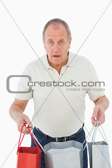 Mature man feeling buyers remorse holding bags