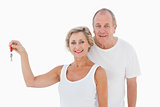 Mature couple smiling at camera with new house key