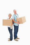 Older couple smiling at camera holding moving boxes