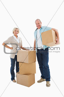 Older couple smiling at camera with moving boxes