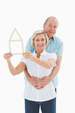 Happy older couple holding house shape