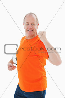 Mature man in orange tshirt cheering holding football