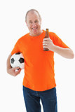 Mature man in orange tshirt holding football and beer