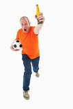 Mature man in orange tshirt holding football and beer
