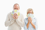Happy mature couple smiling at camera showing money