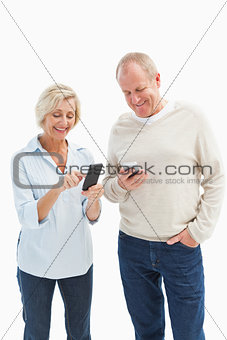 Happy mature couple using their smartphones