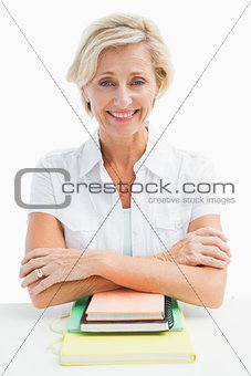 Happy mature student sitting with notebooks