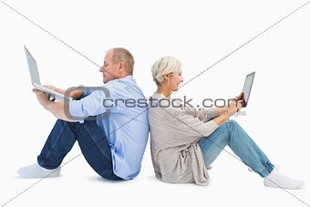 Mature couple using laptop and tablet pc