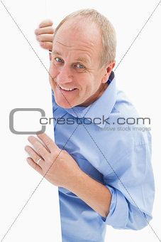 Mature man smiling at camera around card