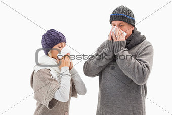 Sick mature couple blowing their noses
