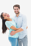 Attractive young couple hugging and smiling at camera