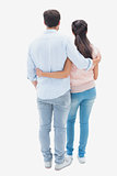 Attractive young couple standing with arms around