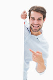 Attractive young man smiling and holding poster