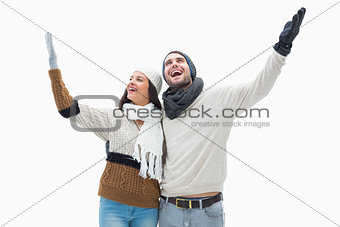 Attractive young couple in warm clothes with arms up