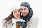 Attractive young couple in warm clothes blowing