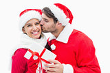 Attractive festive man giving girlfriend a kiss and present