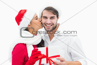 Attractive festive woman giving boyfriend a kiss and present