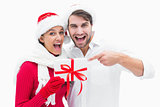 Attractive festive couple pointing to present