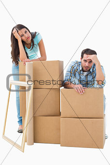 Stressed young couple with moving boxes