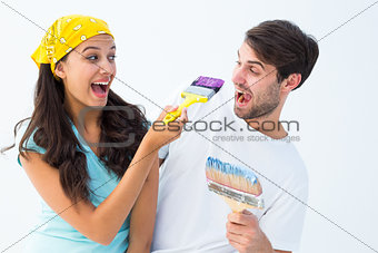 Happy young couple painting together and laughing
