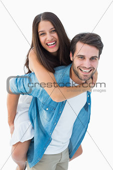 Happy hipster giving his girlfriend a piggy back