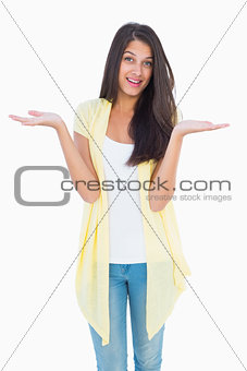 Happy casual woman shrugging her shoulders