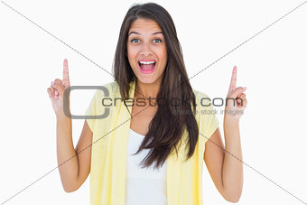 Happy casual woman pointing up