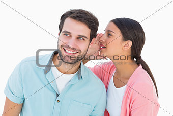 Brunette whispering secret to her boyfriend
