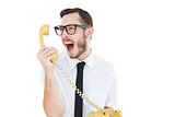Geeky businessman shouting at telephone