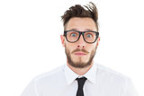 Geeky young businessman looking at camera